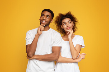 Wall Mural - Young couple day dreaming on orange background