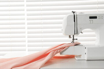 Poster - Sewing machine and fabric on white table indoors