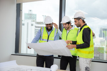 Construction engineer with technician designer team working build site inspect for interior renovate in industry workshop building with floor plan.