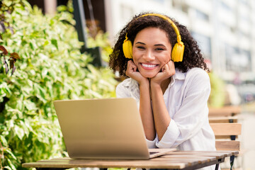 Sticker - Photo of shiny adorable lady wear white shirt headphones sitting cafeteria distance college studying device outside urban city park