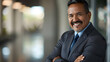 © Generative AI - Handsome hispanic senior business man with crossed arms smiling at camera Indian or latin confident mature good looking middle age leader male businessman on blur office background wit : Generative AI