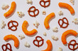 © Tetra Images - Overhead view of pretzels, cheese puffs and popcorn on white background