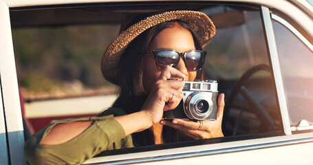 Wall Mural - Woman, photographer and car with camera for road trip, sunset or memory on outdoor journey in nature. Female person with hat and sunglasses for capture, picture or sightseeing on adventure or tour