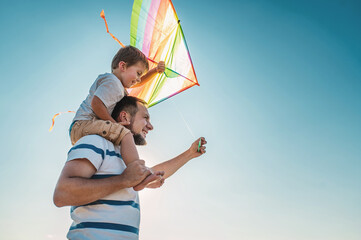 dad and little son 3 years old fly a kite in a field. Involved Parenting, International Father's Day