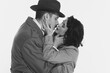 © master1305 - Portrait of happy young couple, man and woman in retro-styled clothes, coats standing and kissing. Monochrome image. Concept of retro and vintage, fashion, romance, relationship