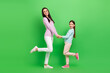 © deagreez - Full length photo of pretty excited little girl mom dressed casual clothes dancing holding arms isolated green color background