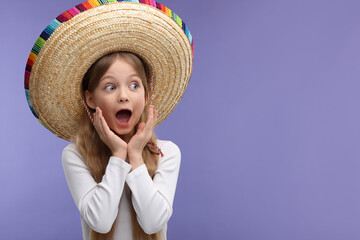 Wall Mural - Emotional girl in Mexican sombrero hat on purple background. Space for text