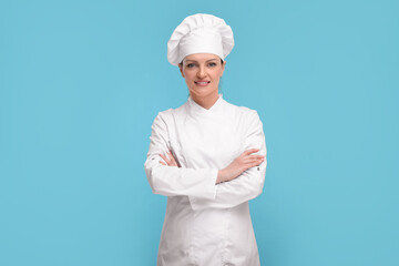 Canvas Print - Happy chef in uniform on light blue background