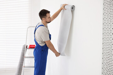 Poster - Man hanging stylish gray wallpaper in room