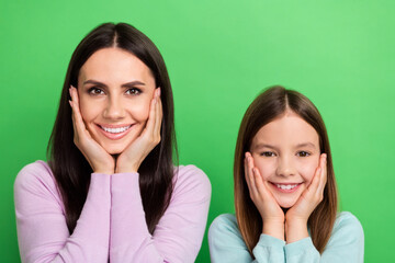 Poster - Photo of dreamy sweet little girl mom dressed casual clothes arms cheeks smiling isolated green color background