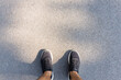Fitness and healthy lifestyle concept. Man looking running sneakers on a asphalt road in the morning. Top view and copy space