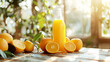 An orange juice in a glass bottle and oranges on a table with a blurred background of a window on a bright sunny day.