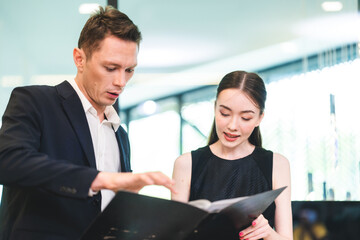 Wall Mural - confident businessman wearing glasses signing contract at group negotiations, business partners making successful investment deal, agreement, salesman putting signature on legal documents