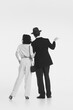 © master1305 - Man and woman in retro-style elegant costumes standing and looking somewhere with attention isolated on white background. Black and white. Concept of retro and vintage, fashion, romance, relationship
