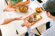 © chokniti - Waitress man serving food to group of diverse customer in restaurant, eatery client woman and man having smile and happy with service mind from cafes staff, lunch or dinner time lifestyle with family
