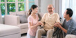 © chokniti - Celebrating Father's Day, Senior Asian grandfather in a wheelchair shares a happy moment at home, hugging his family together, symbolizing generational love and care, health care and life insurance