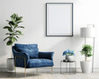 A cozy living space with an empty frame ready for artwork, surrounded by a sophisticated blue chair and vibrant house plants