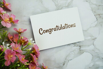 Poster - Congratulations text message on paper card with flower decoration on marble background