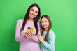© deagreez - Photo of cheerful cute little girl mom dressed casual clothes chatting instagram telegram facebook isolated green color background
