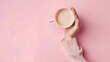 Female hand hold coffee cup on pink background Top view : Generative AI