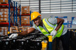 © chokniti - African American person working to shipping box package by order in logistic warehouse, black male work in delivery distribution job service in storage factory, man checking good of industry business