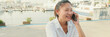 © Andrii Nekrasov - Young woman talking on mobile phone on seascape background, Panorama