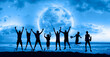 A group of young people jumping under the moonlight by the sea  