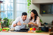 © StockImageFactory - Indian couple in kitchen - Young Beautiful asian wife enjoying cooking with husband.