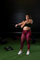 young female athlete in sportswear stretching after exercising