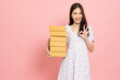 Young Asian woman holding package parcel box isolated on pink background, Delivery courier and shipping service concept