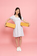 Young Asian woman holding package parcel box isolated on pink background, Delivery courier and shipping service concept