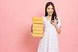 Fototapeta  - Young Asian woman holding package parcel box isolated on pink background, Delivery courier and shipping service concept