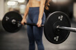 Close up of a strong sportswoman doing deadlifts in a gym.