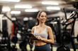 © Dusan Petkovic - Portrait of a female fitness trainer standing in a gym with tablet in her hands.