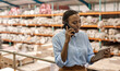 African woman with a tablet talking on a phone in a warehouse