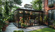A stunning black and glass greenhouse, situated in the backyard of an elegant Victorian-style mansion. The structure features tall windows with ornate frames that reveal lush greenery within.  