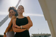 Two young female sportswomen have a rest after morning jogging standing outdoors and looks camera