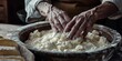 Seasoned hands of an old woman kneading dough in a wooden bowl, illustrating traditional homemade cooking