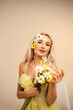 Portrait of a pretty girl with a bouquet of chrysanthemums. White and yellow flowers and petals on the face. Beauty concept