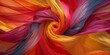 Closeup of swirling fabric texture in vibrant orange, red, purple, and yellow hues, depicting movement and fluidity