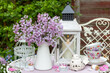romantische Dekoration mit Flieder-Strauß, weißer Laterne und vintage Tassen	
