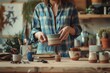 A craftsperson carefully examines a unique handmade ceramic bowl in a cozy, artistic studio setting