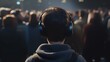 Back view of young man listening to music with headphones at concert.