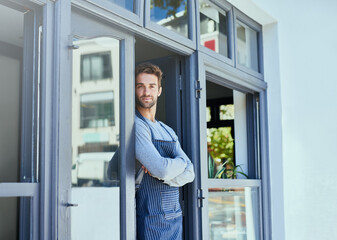 Poster - Door, crossed arms and portrait of waiter by coffee shop with positive, happy and confident attitude. Smile, pride and man barista standing by cafe or restaurant entrance for welcome in hospitality.