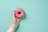 Fototapeta Most - Person Holding Pink Donut With Sprinkles
