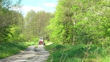 Small Brown Tractor Is Driving Along Road