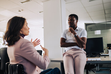 Wall Mural - African american businessman talking with his woman with disability colleague