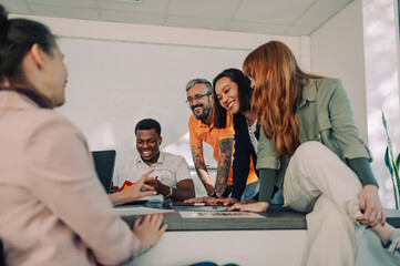 Wall Mural - Couple of diverse business people having a meeting with their team at the office