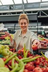 Happy customer buying fresh tomato at farmer's market.