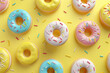 brightly colored donuts with sprinkles on a sunny yellow background